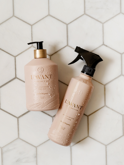 Wet bottles of Blushed Bergamot scented products on hexagon tiles