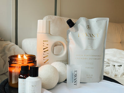 Laundry detergent, eco-friendly laundry soap refills, wool dryer balls, detergent measuring cups, laundry oil, and a candle