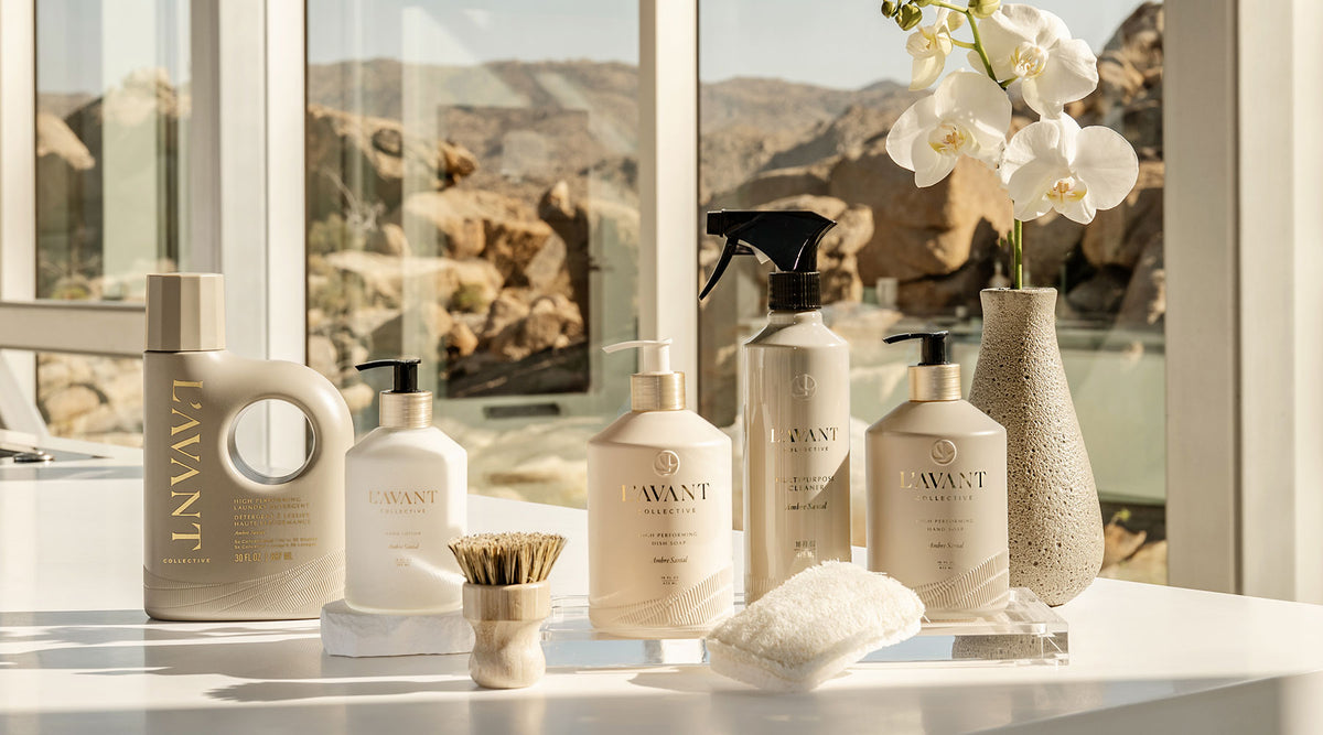 A collection of high performance cleaning products in the Ambre Santal scent featured clustered together on a counter top.
