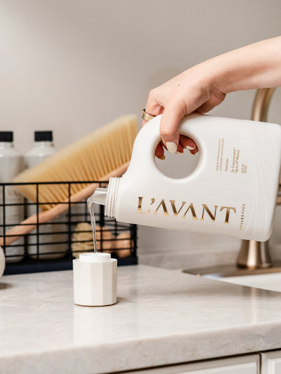Pouring L'AVANT Collective non-toxic liquid laundry detergent